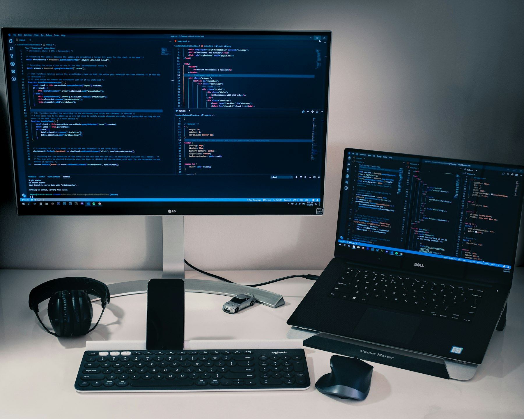 Monitor and laptop showing code on a desk